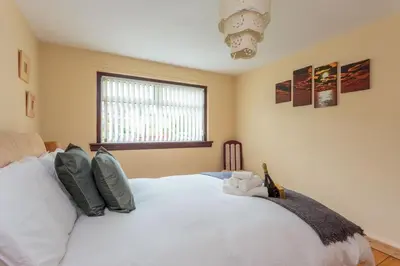 a bedroom with a white bed with a stuffed animal on it at Free Parking - City Centre - 3 Bedrooms - 5 Guests in Edinburgh