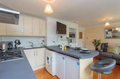 a kitchen and living room with a sink and a stove at Free Parking - City Centre - 3 Bedrooms - 5 Guests in Edinburgh