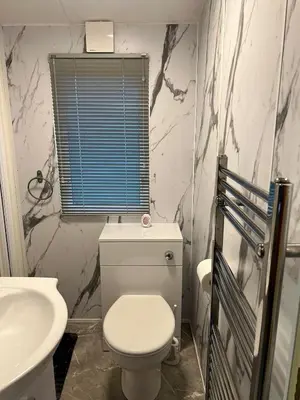 a bathroom with a white toilet and a sink at 108 Lochview in Newton Stewart
