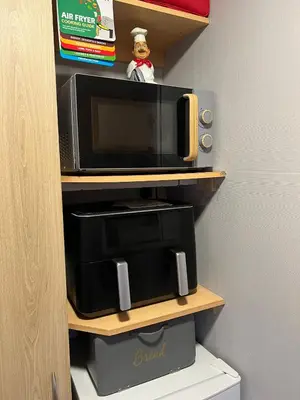 a microwave on a shelf with a toy on top of it at 108 Lochview in Newton Stewart