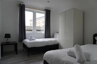 a bedroom with two beds and a window at Glasgow Group Getaway in Glasgow