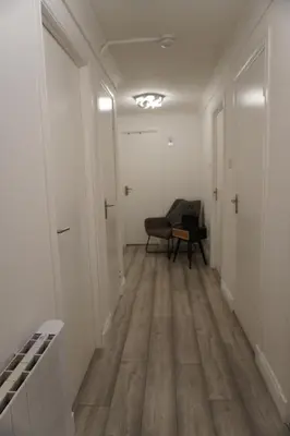 an empty hallway with a chair in a room at Glasgow Group Getaway in Glasgow