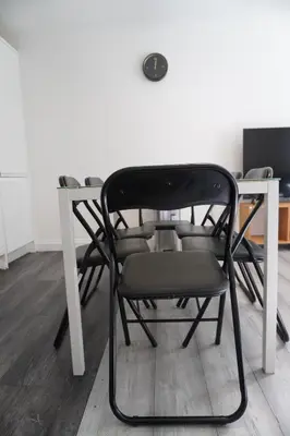 a black chair sitting next to a white table at Glasgow Group Getaway in Glasgow