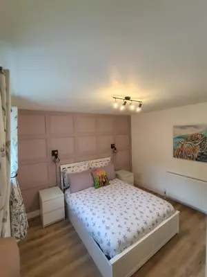 a bedroom with a white bed with two pillows at Millburn Chalet in Inverkip