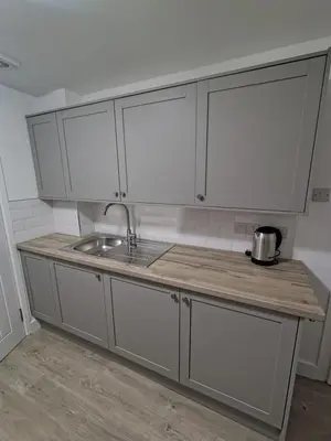 a kitchen with white cabinets and a sink at Millburn Chalet in Inverkip