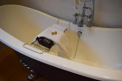 a bath tub with a towel on the side of it at The Allanbreck Studio Glencoe Ballachulish Highlands Near Fortwilliam in Glencoe