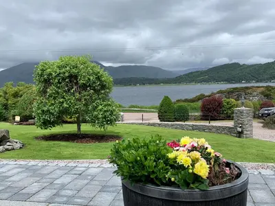 a planter with flowers and a tree in a park at The Allanbreck Studio Glencoe Ballachulish Highlands Near Fortwilliam in Glencoe