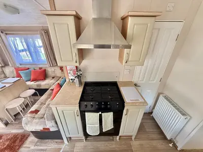 a kitchen with a stove top oven in a room at Deluxe Delta 4-Bedroom Caravan Located at Maryville Caravan Site Uddingston, Glasgow in Uddingston