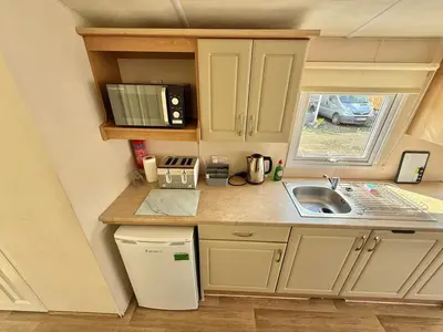 a small kitchen with a sink and a microwave at Deluxe Delta 4-Bedroom Caravan Located at Maryville Caravan Site Uddingston, Glasgow in Uddingston