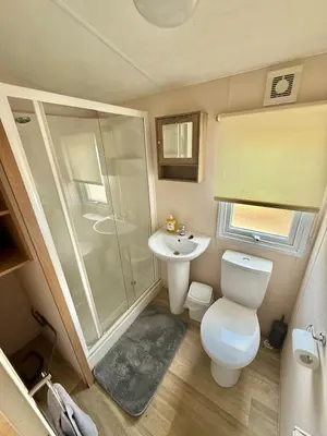 a bathroom with a shower and a toilet and a sink at Deluxe Delta 4-Bedroom Caravan Located at Maryville Caravan Site Uddingston, Glasgow in Uddingston