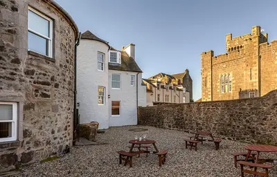 a courtyard with picnic tables in front of a building at Castle Street Apartments - Luxury Kerrycroy Ground Floor Apartment in Rothesay