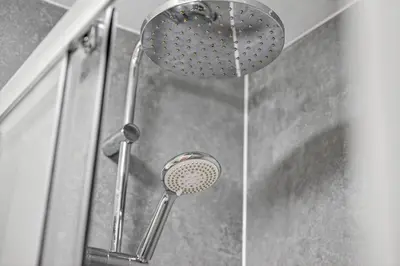 a shower with a shower head in a bathroom at Modern 2-Bedroom flat in Glasgow city centre, near Galsgow Green in Glasgow
