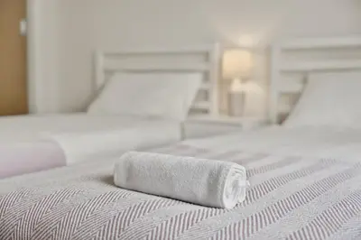 a rolled up white towel on a bed at Modern 2-Bedroom flat in Glasgow city centre, near Galsgow Green in Glasgow