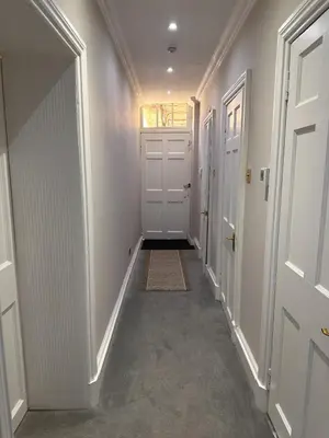 a hallway with two white doors and a rug at Walker Apartment in Edinburgh