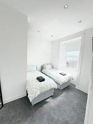 a bedroom with two beds and a window at 2Bed Gla Green, Walk Dist City Centre in Glasgow
