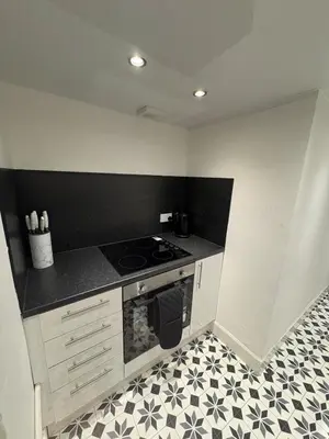 a kitchen with a stove and a black and white floor at 2Bed Gla Green, Walk Dist City Centre in Glasgow