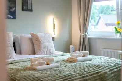 a bedroom with a bed with towels on it at Entire Home in Renfrewshire in Elderslie