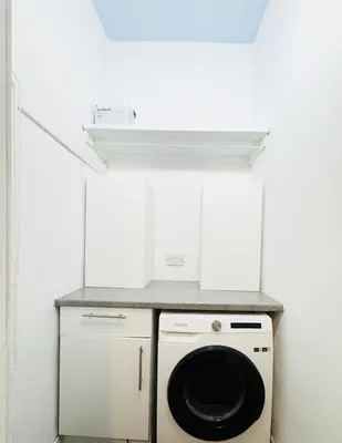 a kitchen with a washer and dryer in a room at Stylish Flat in Historic Edinburgh city centre home in Edinburgh