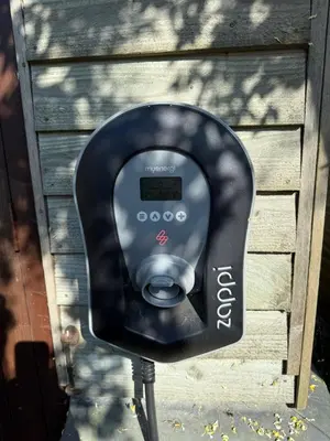 a black parking meter in front of a building at Cosy Cottage in Cotswolds in Moffat
