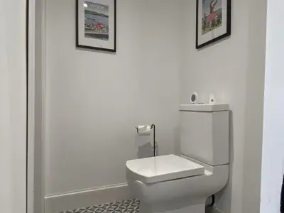 a white bathroom with a toilet and two pictures on the wall at Thornlie - Uk49875 in Blairmore