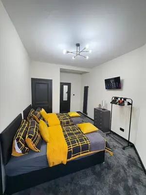 a bedroom with a bed with yellow blankets and pillows at 3BR West End Flat w Free Parkin in Glasgow