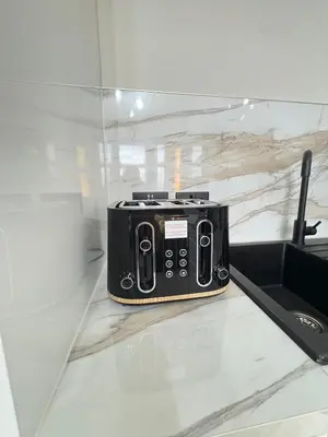 a black toaster sitting on a counter next to a sink at 3BR West End Flat w Free Parkin in Glasgow