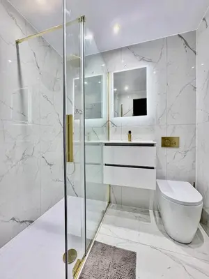 a white bathroom with a shower and a toilet at 3BR West End Flat w Free Parkin in Glasgow