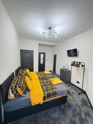 a bedroom with a bed with yellow blankets and pillows at 3BR West End Flat w Free Parkin in Glasgow