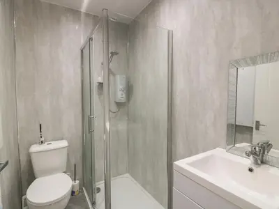 a bathroom with a shower and a toilet and a sink at Cosy In in Millport