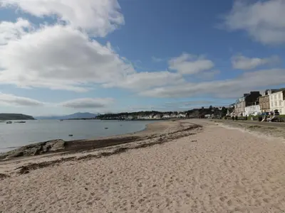 a sandy beach with buildings and the ocean at Cosy In in Millport