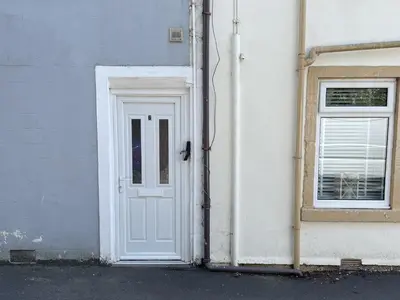 a white door and a window on a building at Cosy In in Millport