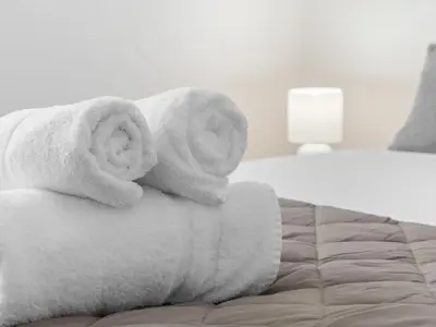 a pile of towels sitting on top of a bed at Ludgate 2 Bedroom Apartment - Alloa in Alloa