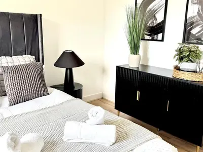 a bedroom with a bed and a dresser with towels at Newtown Hideaway in Boʼness