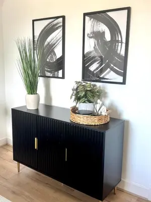 a black dresser with two potted plants on it at Newtown Hideaway in Boʼness