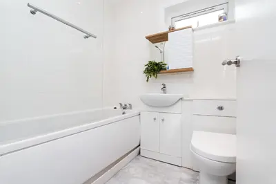 a white bathroom with a sink and a toilet at 2 Bedroom House-Free Parking in Rosyth