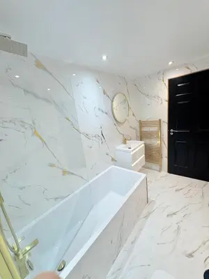 a bathroom with a tub and a clock on the wall at F1 2BR Free Parking Walk Dist CityC in Glasgow