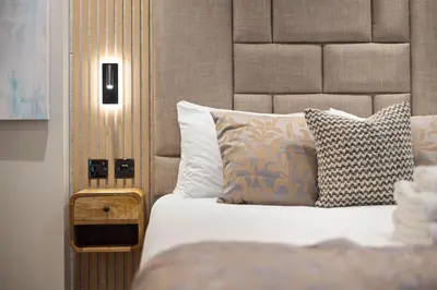 a bedroom with a bed with a headboard and a pillows at City Centre Luxury Studio for 2 in Edinburgh