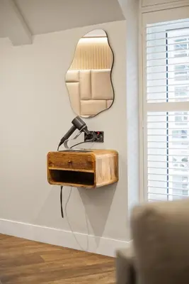 a mirror hanging on a wall next to a couch at City Centre Luxury Studio for 2 in Edinburgh