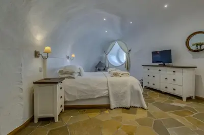 a bedroom with a bed and a dresser and a mirror at The Warren - Hobbit House and Hot Tub at Loch Tay in Lawers