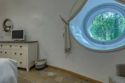 a room with a round window in a bedroom at The Warren - Hobbit House and Hot Tub at Loch Tay in Lawers