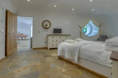 a bedroom with a large bed and a window at The Warren - Hobbit House and Hot Tub at Loch Tay in Lawers