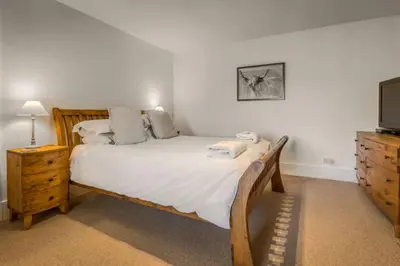 a bedroom with a large bed and a television at Loch Tay, Estate House with Panoramic Vistas in Lawers