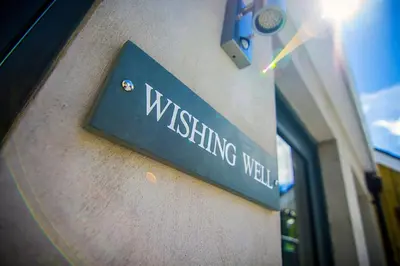 a sign on a wall that reads wishing wall at Wishing Well Cottage at Loch Tay and Hot Tub in Lawers