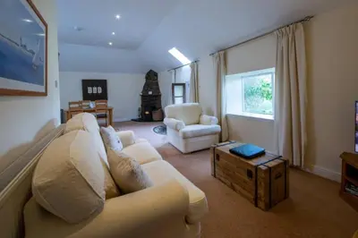 a living room with a couch and a table at Loch Tay Bothy Cottage with Hot Tub in Lawers
