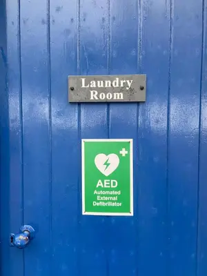 a sign on a blue door with a laundry room sign at Fordie Lodge in Comrie
