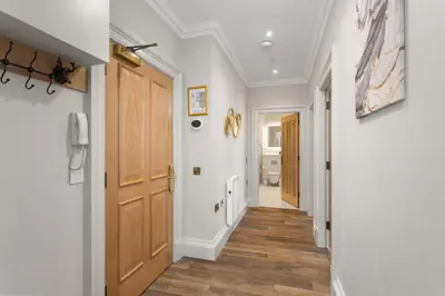 a hallway with white walls and a wooden door at Prime Central Edinburgh 2 bed in Edinburgh