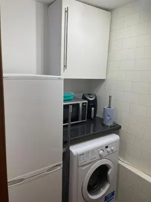 a kitchen with a washing machine and a microwave at Quirky Cottage Central Bathgate in Bathgate