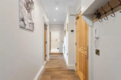 a hallway with white walls and wood flooring at Prime Central Edinburgh 2 bed in Edinburgh