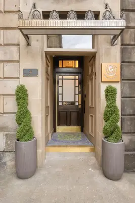 two bushes in pots in front of a door at Prime Central Edinburgh 3 bed in Edinburgh