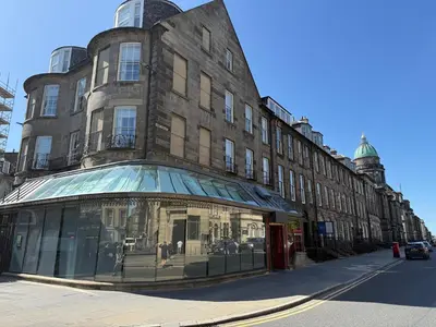 a large brick building with a store window on a street at Central Edinburgh Prime Luxury in Edinburgh